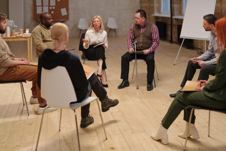 Large group of contemporary people with psychological problems sitting on chairs in circle